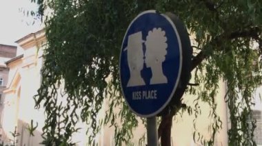 Road sign places to kiss under a tree in summer. High quality 4k footage