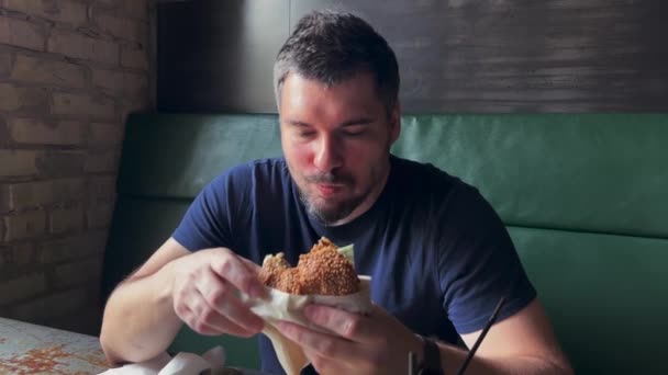 Unshaven Man Eats Meat Burger Man Sitting Green Sofa Eat — Wideo stockowe