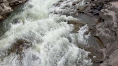  Taş kayaların arasından akan temiz bir akarsu. Vahşi dağ nehir suyu yaz gününde sıçrıyor..