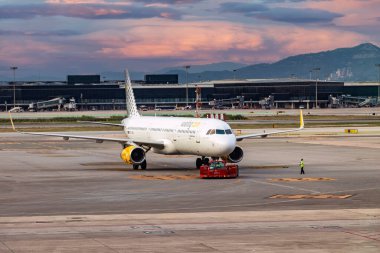 Barcelona, İspanya - 24 Eylül 2021: Bir Vueling uçağının kalkış manevrası için Josep Tarradellas - El Prat Havaalanı 'nda Traktör