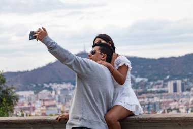 Barselona, İspanya - 19 Eylül 2022: Mutlu bir çift cep telefonlarıyla selfie çekiyor