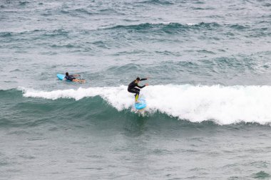 Barselona, İspanya - 24 Eylül 2021: Dalgıç kıyafetli sörfçü bir dalga yakaladı