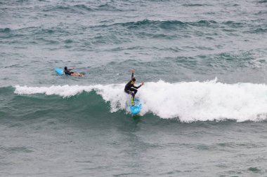 Barselona, İspanya - 24 Eylül 2021: Dalgıç kıyafetli sörfçü bir dalga yakaladı