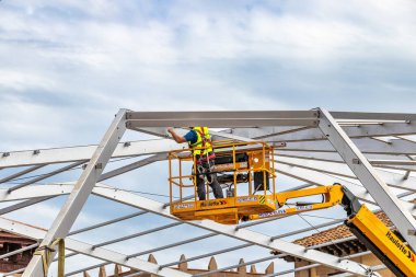 Barselona, İspanya - 22 Eylül 2021: Bir işçi kaldırma platformundaki olaylar için bir çadırın metal çerçevesini birleştiriyor