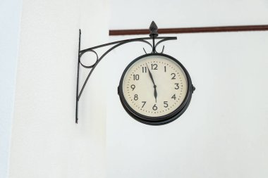 Beyaz bir duvarın üzerindeki eski duvar saati.