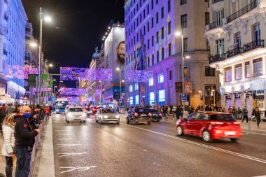 Madrid, İspanya - 11 Aralık 2021: Madrid 'de yürüyen kimliği belirsiz bir kalabalık Noel zamanı dekore edildi. Korumalı yüz maskesi ya da kovid 19 Coronavirus 'a karşı tıbbi maske takıyorlar.