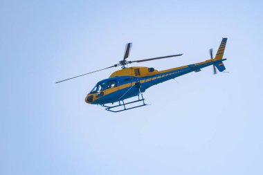 Sarı ve mavi trafik helikopterleri dikkatsiz sürüş kontrolü için yolları ve otobanları kontrol ediyor..
