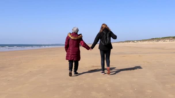 Una Mujer Madura Caminando Con Anciana Madre Junto Playa Otoño — Vídeo de stock