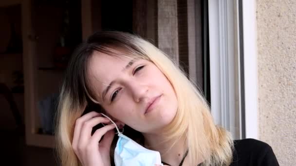 科维德19号验尸官隔离的年轻女子戴上防护面罩 — 图库视频影像