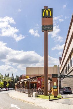 Huelva, İspanya - 19 Mart 2022: McDonald 's McAuto Drive girişte. McDonald 's, 1940 yılında San Bernardino, Kaliforniya, ABD' de kurulan çok uluslu bir fast food şirketidir.