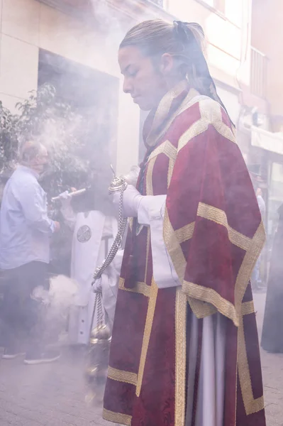 スペインのウエルバ 2022年4月10日 祭壇の少女や女性は 聖なる週の行列で香の煙を生成するために検閲握手を活性化させます 煙のために柔らかい焦点 女の子の頭の中にフォーカス — ストック写真