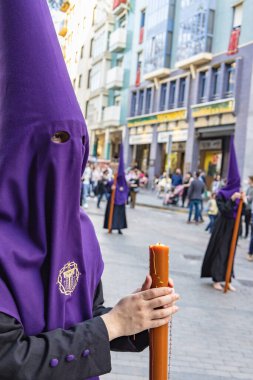 Genç bir Nasıralı 'nın alevindeki mum elinde dua etmek için bir tespihle, günah çıkarma töreninde kefaretini öder.. 