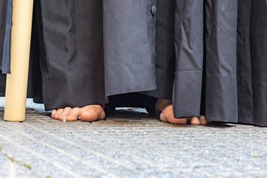 Bir Nasıralı ya da siyah elbiseli bir tövbekar kutsal hafta töreninde çıplak ayakla günah çıkarma işlemektedir.