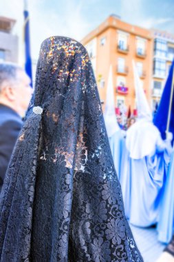 Siyah İspanyol mantilla ve peineta (süs tarağı) taşıyan bir kadının kafasının ayrıntıları, bir kutsal hafta töreninde arkadan görüldü.