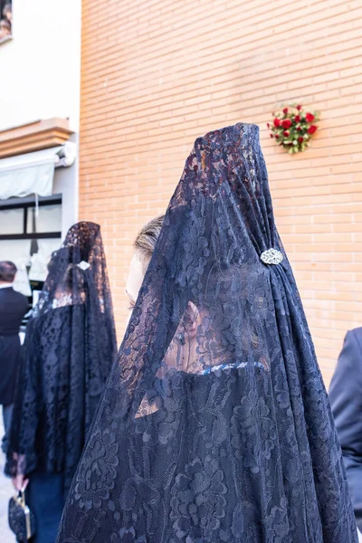 一个女人头颅的细节 她身穿黑色的西班牙式风衣 头戴佩内塔 装饰梳子 从后面看 参加了圣周游行 — 图库照片