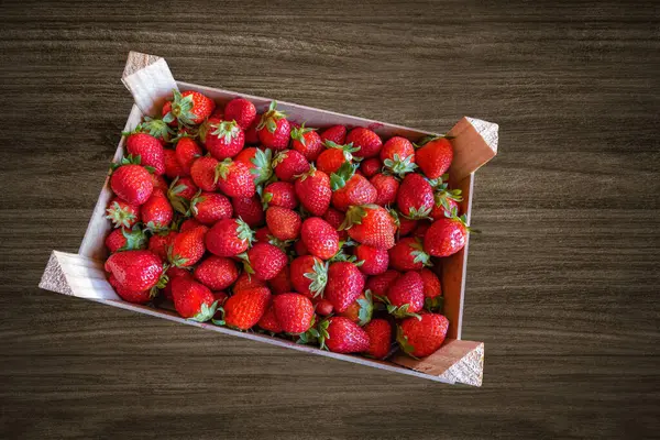 Eine Kiste Erdbeeren Über Einem Holztisch — Stockfoto