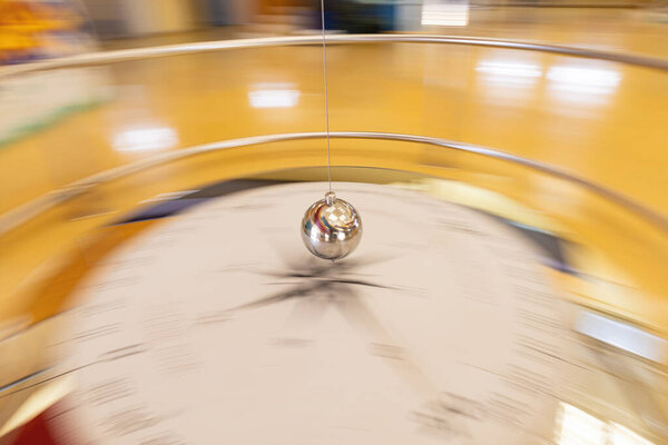 Photographic sweep of a foucault pendulum along its path through a compass rose