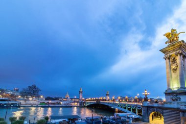 Geceleyin Pont Alexandre III, Paris 'teki Seine nehri boyunca uzanan bir güverte kemer köprüsü. Invalides ve Eyfel Kulesi 'ndekilerle bağlantı kuruyor..