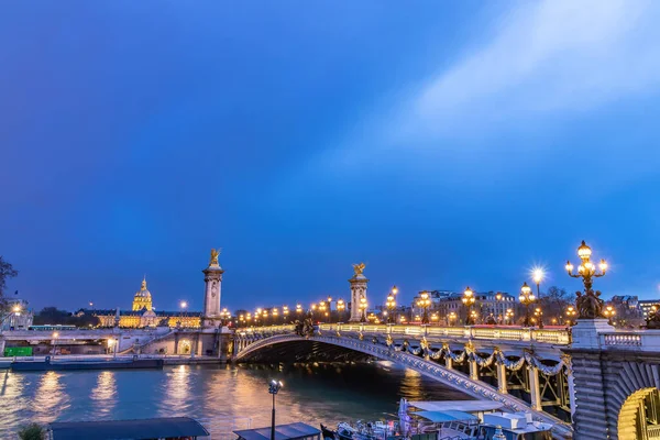夜のポンアレクサンドル3世は パリのセーヌ川に架かるデッキアーチ橋です それはインヴァリッドとエッフェル塔のものと4分の1を結ぶ — ストック写真