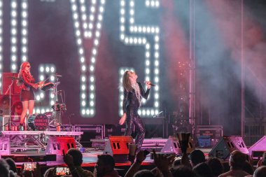 Huelva, Spain - August 1, 2022: The singer Mario Vaquerizo with the band Nancys Rubias, a Spanish musical group of electronic, pop, dance, and glam, in a concert at the Huelva Colombian festival