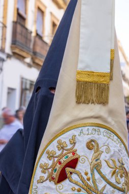 Badge of the Brotherhood and fellowship carried by a penitent in the Holy Week procession. The text 
