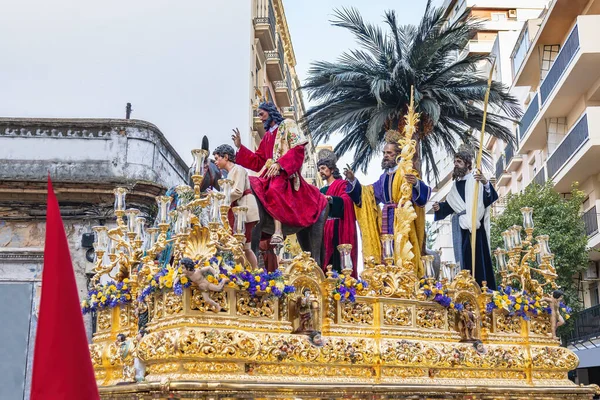 Christ riding a donkey in the Throne or platform of the Brotherhood of the La Borriquita, in procession by the narrow streets of the city