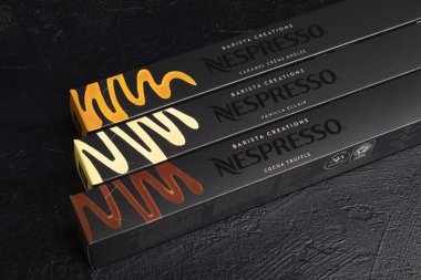 Novosibirsk, Rusya, 19 Mart 2021 - Siyah arka planda çeşitli aromalı nespresso kahve seti. Karamelli, vanilyalı, kakaolu mantarlı. Nespresso küresel bir kahve şirketi.