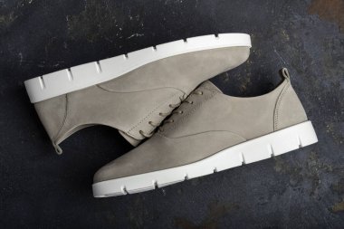 Koyu arkaplanda bir çift gri ayakkabı. Yukarıdan görüntüle