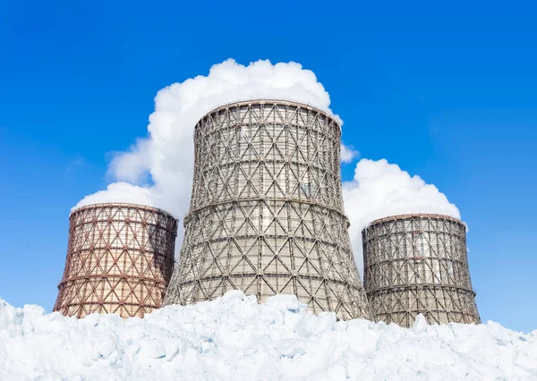 Chpの3つの急上昇する蒸発器と青空に対する雪の多く 工業用煙やカップルの白い雲はきれいな空に上昇します — ストック写真
