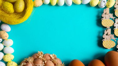 Mavi arkaplandaki metin için paskalya yumurtaları ve kopyalama alanı ile çerçevele.