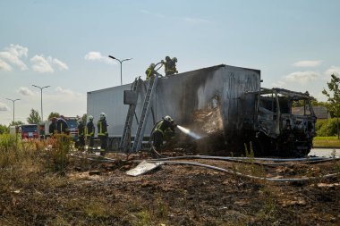 23 Temmuz 2021, Riga, Letonya. Yanan bir arabayı söndüren itfaiyeciler.. 