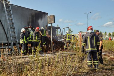 23 Temmuz 2021, Riga, Letonya. Yanan bir arabayı söndüren itfaiyeciler.. 