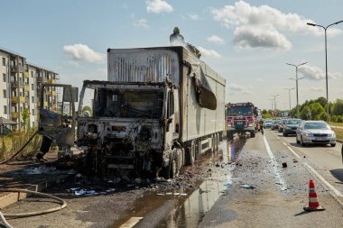 23 Temmuz 2021, Riga, Letonya. Yanan bir arabayı söndüren itfaiyeciler.. 
