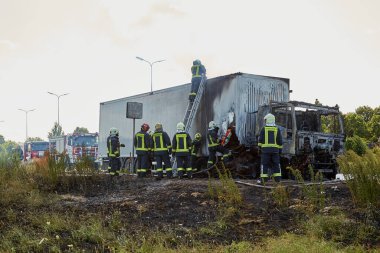 23 Temmuz 2021, Riga, Letonya. Yanan bir arabayı söndüren itfaiyeciler.. 