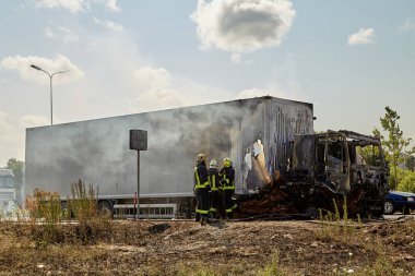 23 Temmuz 2021, Riga, Letonya. Yanan bir arabayı söndüren itfaiyeciler.. 