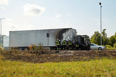 23 Temmuz 2021, Riga, Letonya. Yanan bir arabayı söndüren itfaiyeciler.. 
