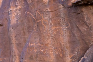 ancient petroglyphs on cave wall in Saudi Arabia