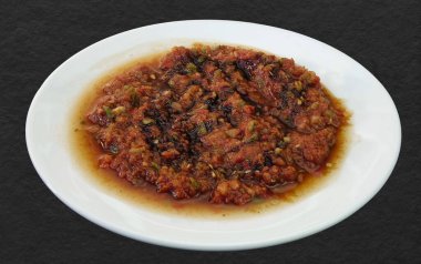 Geleneksel Türk Aperatifi Acili Ezme. Türk mezesi Acuka taze domates, yeşil biber, salatalık ve baharattan yapıldı. Geleneksel Türk aperatifi Acili Ezme beyaz tabakta servis edildi. İzole edilmiş.