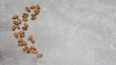 Gri arkaplanda yarım ay şeklinde dizilmiş badem resimleri, boş uzayda metin için elverişli