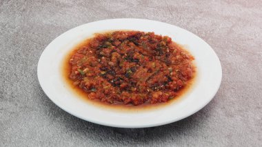 Geleneksel Türk Aperatifi Acili Ezme. Türk mezesi Acuka taze domates, yeşil biber, salatalık ve baharattan yapıldı. Geleneksel Türk Aperatifi Acili Ezme beyaz tabakta servis yaptı