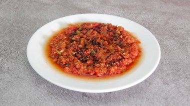 Geleneksel Türk Aperatifi Acili Ezme. Türk mezesi Acuka taze domates, yeşil biber, salatalık ve baharattan yapıldı. Geleneksel Türk Aperatifi Acili Ezme beyaz tabakta servis yaptı