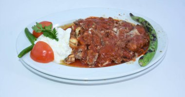 Yoğurt, kavrulmuş biber ve domatesle servis edilen İskender Kebap manzarası. Geleneksel Türk donör kebap.