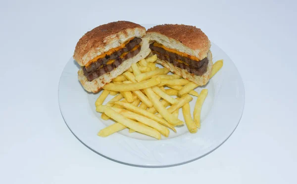 芝士汉堡切成两半 炸薯条放在白盘上的头像 — 图库照片