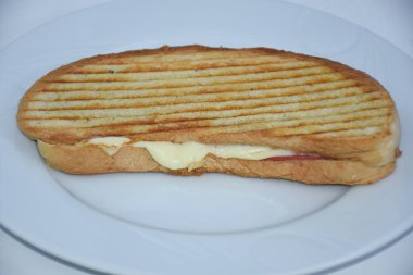 Peynirli tost, tenha bir tabakta servis edilir.