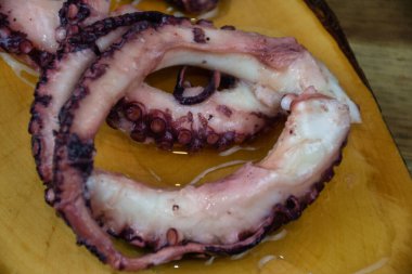 Ahşap tepside zeytinli marine edilmiş ahtapot manzarası.