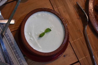 Geleneksel Ege bufalo yoğurdu ve seramik kasede ahşap masada. Kapat..