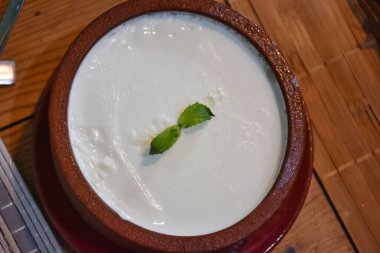 Geleneksel Ege bufalo yoğurdu ve seramik kasede ahşap masada. Kapat..