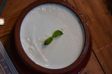 Geleneksel Ege bufalo yoğurdu ve seramik kasede ahşap masada. Kapat..