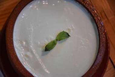 Geleneksel Ege bufalo yoğurdu ve seramik kasede ahşap masada. Kapat..
