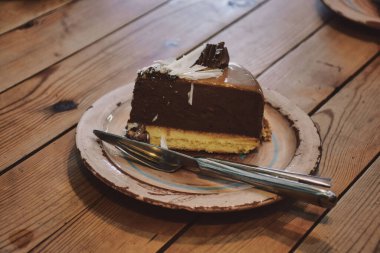 Tahta bir masada seramik tabakta çikolatalı pasta.